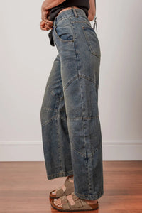Person wearing wide-leg jeans on a plain background