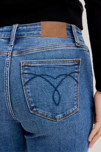 Close-up of blue jeans with a brand logo on the back pocket.