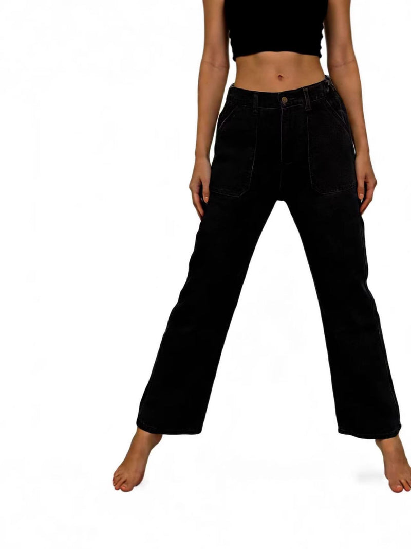Person wearing black high-waisted jeans on a white background