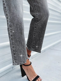 Close-up of gray jeans with sparkling embellishments on a light background