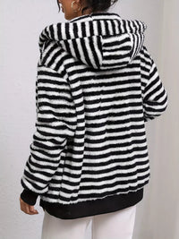 Black and white striped fleece jacket worn by a person on a plain background