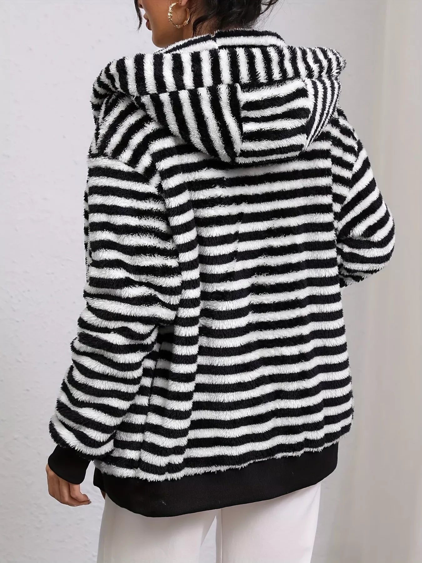 Black and white striped fleece jacket worn by a person on a plain background