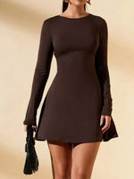 Woman wearing a brown long-sleeve dress against a beige background