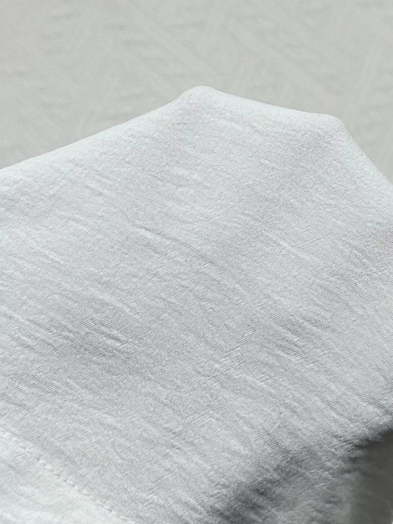 Close-up of a textured gray fabric on a light gray background