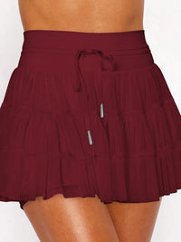 Maroon tiered skirt worn by a person on a white background