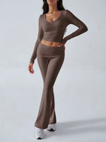 Woman wearing a brown long-sleeve top and flared pants on a white background