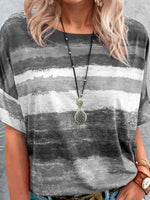 Person wearing a gray and white striped shirt with a necklace.