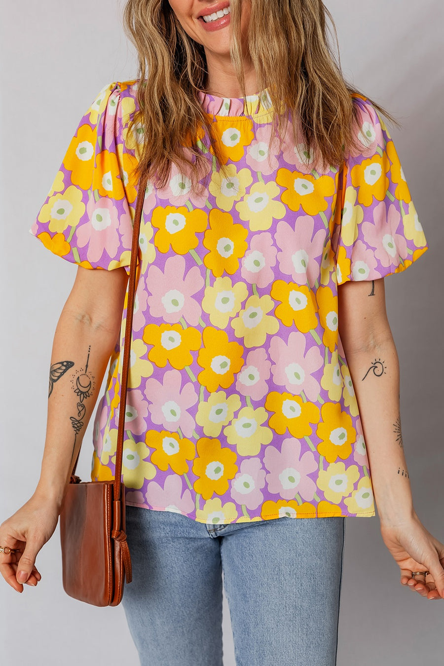 Woman wearing a colorful floral blouse with a plain background
