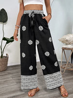 Person wearing black pants with white patterns indoors
