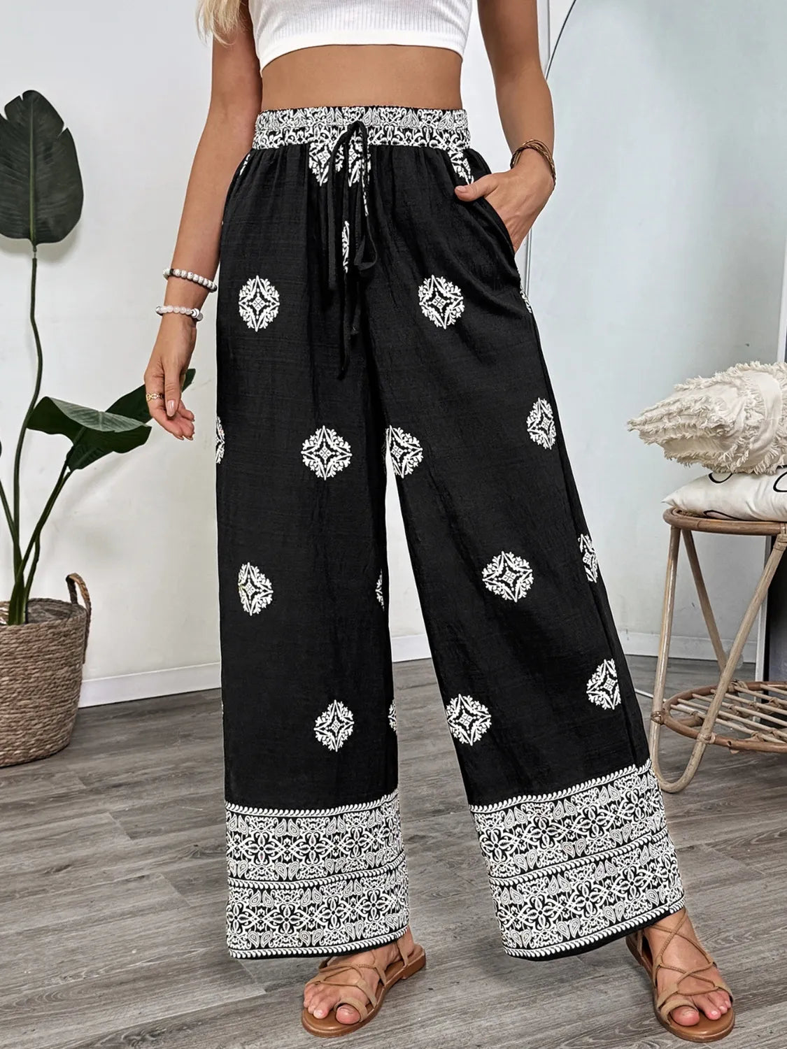 Person wearing black pants with white patterns indoors