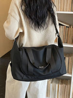 Person holding a black handbag in a room with bookshelves.