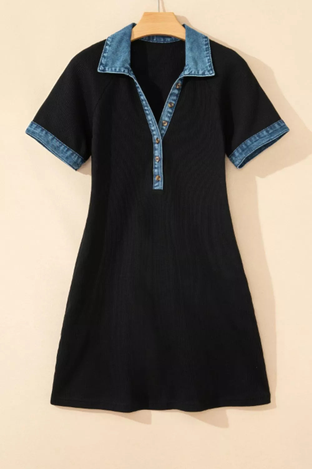 Black dress with denim collar on a beige background