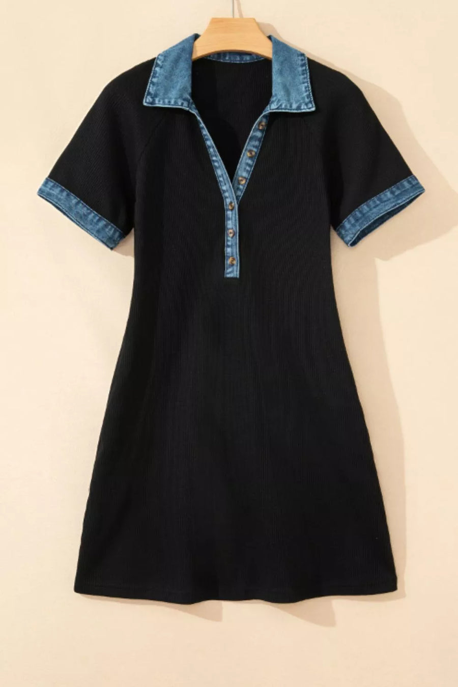 Black dress with denim collar on a beige background