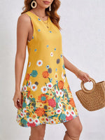 Woman wearing a yellow floral dress holding a woven bag against a white background