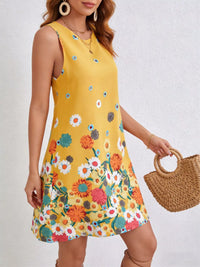 Woman wearing a yellow floral dress holding a woven bag against a white background