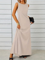 Woman wearing a beige sleeveless dress against a light wooden panel background