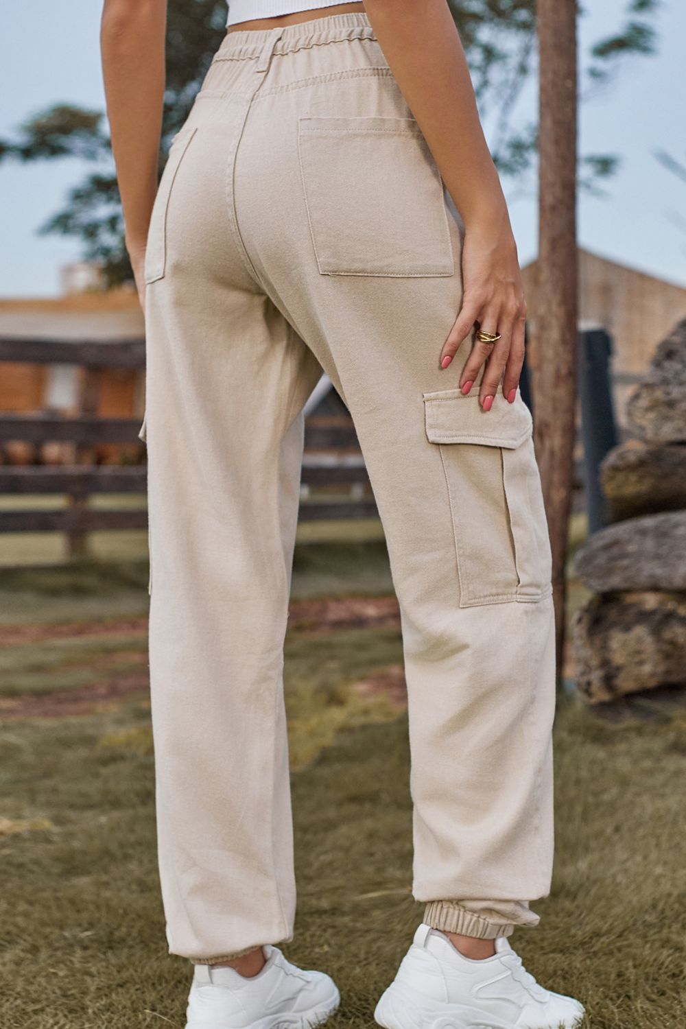Person wearing beige cargo pants with a blurred outdoor background