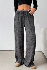 Person wearing gray checkered pants with a white background