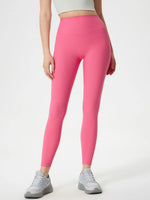 Person wearing bright pink leggings on a white background