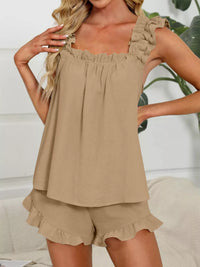 Woman wearing a beige sleeveless top and shorts set with a white background