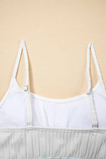 White spaghetti strap top on a beige background
