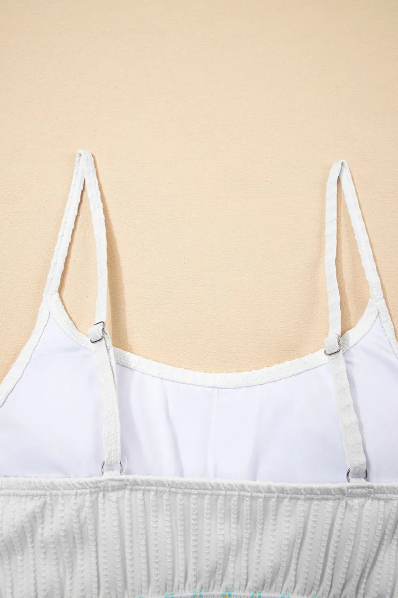 White spaghetti strap top on a beige background
