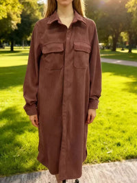 Person wearing a brown dress standing in a park