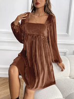 Woman wearing a brown pleated dress in an indoor setting