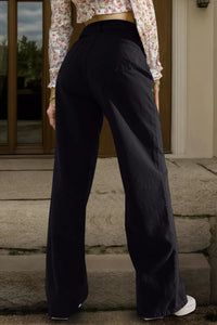 Person wearing black pants standing on stone steps with a floral shirt visible