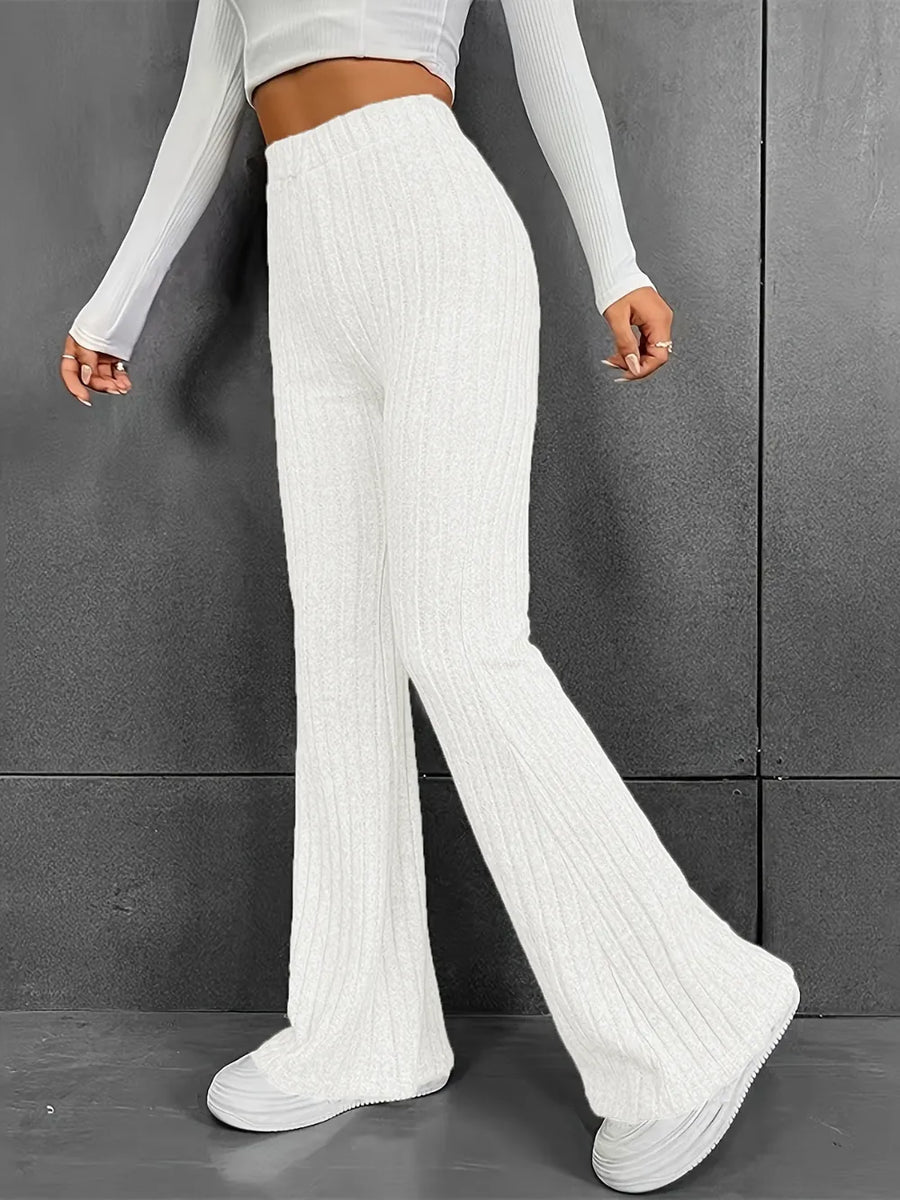 Person wearing white ribbed knit pants against a gray background