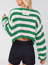 Green and white striped sweater worn by a person on a plain background