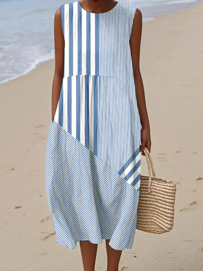 Woman wearing a blue and white striped dress on a beach.