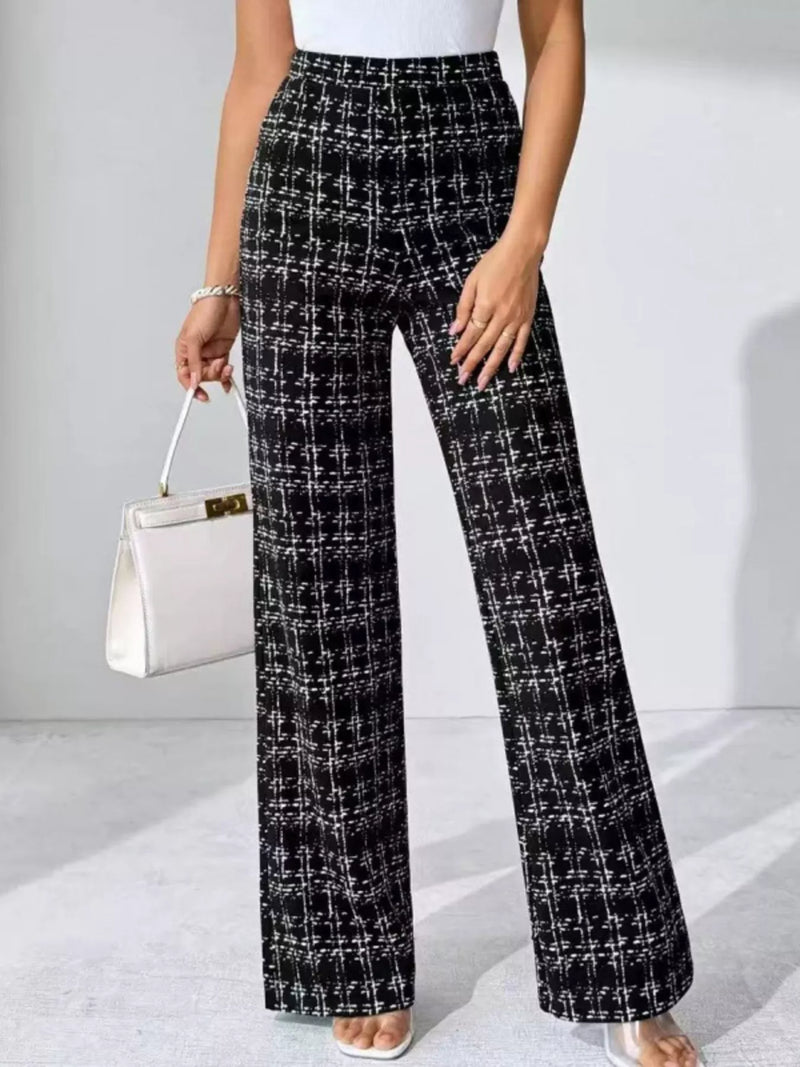 Person wearing black and white checkered pants holding a white handbag on a light gray background