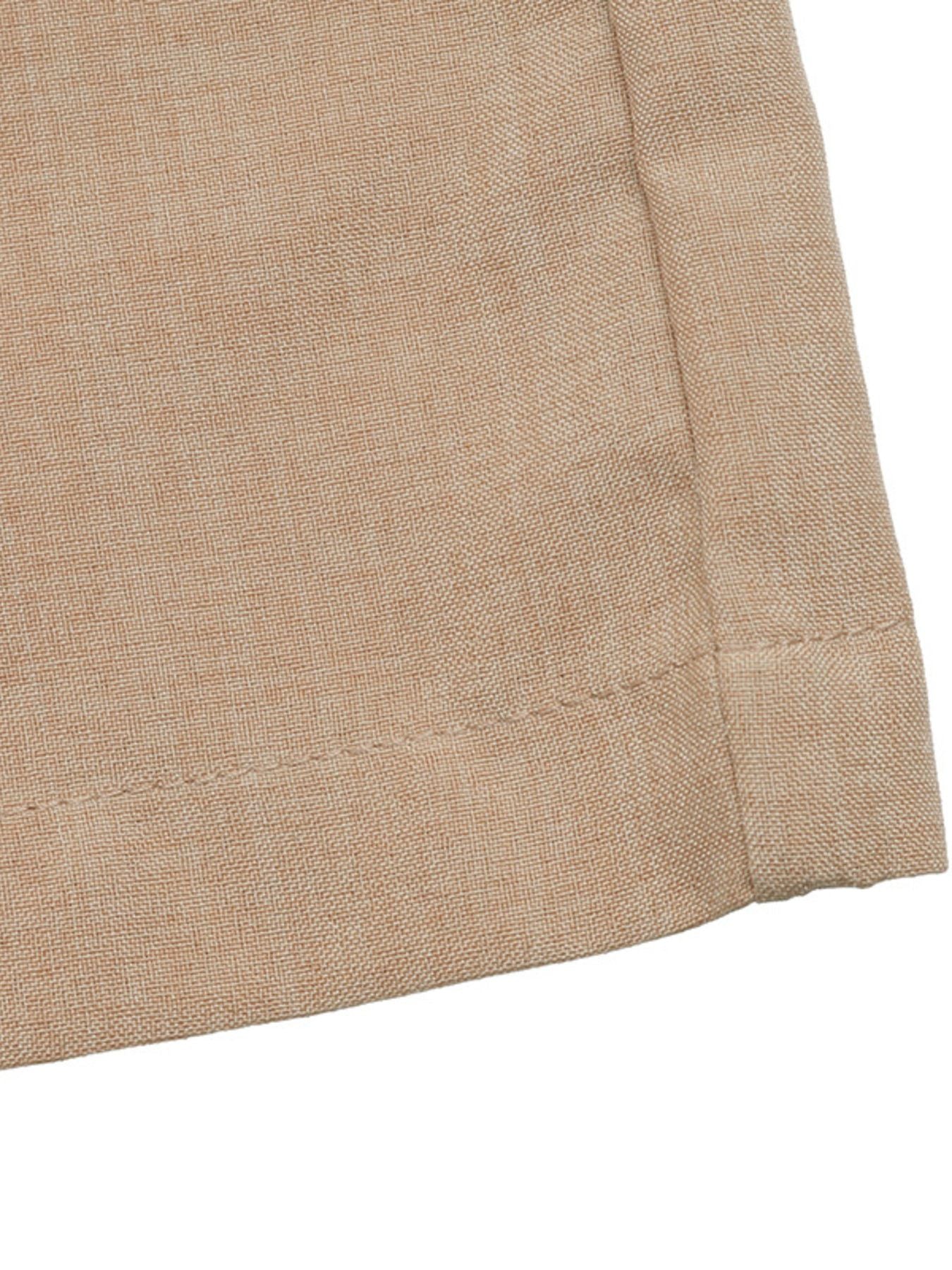 Close-up of beige fabric with a visible seam on a white background