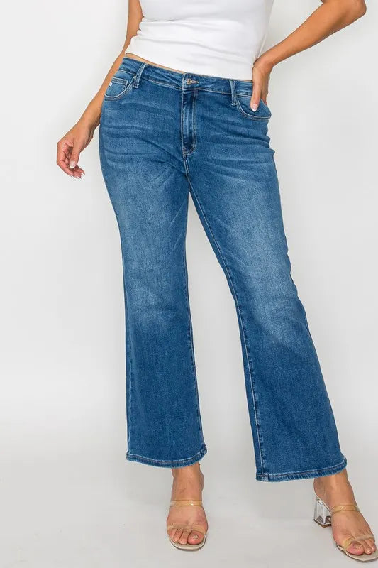 Person wearing blue jeans and a white top on a plain background