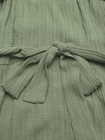 Close-up of a green textured garment with a tie detail.