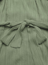 Close-up of a green textured garment with a tie detail.
