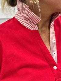 Close-up of a red shirt with a white and red striped collar.