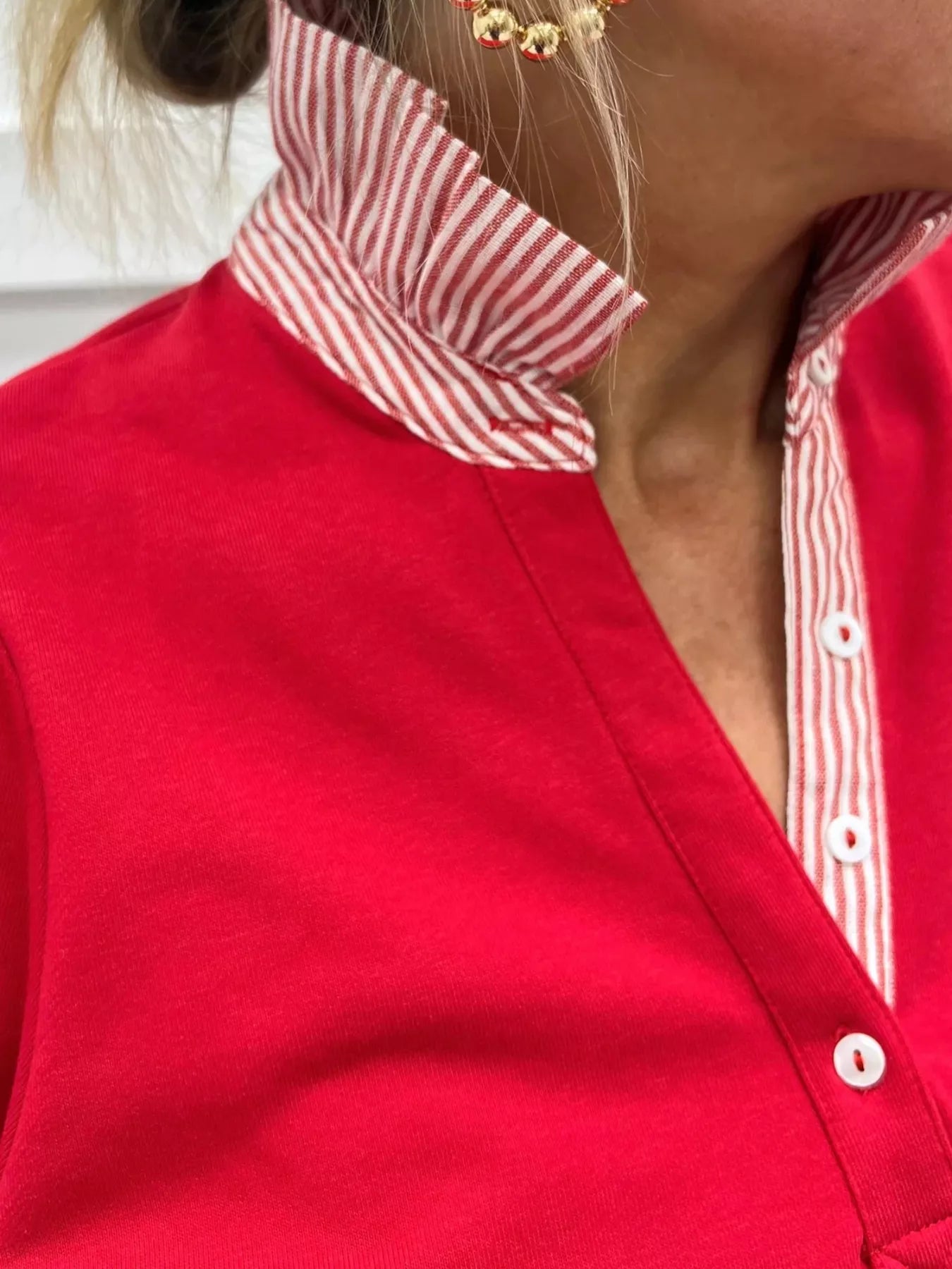 Close-up of a red shirt with a white and red striped collar.