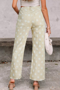 Person wearing light green polka dot pants with a neutral background