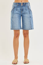 Denim shorts worn by a person on a white background