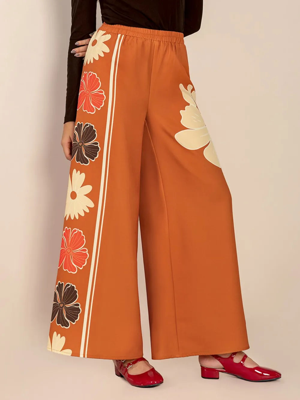 Orange pants with floral patterns on a beige background