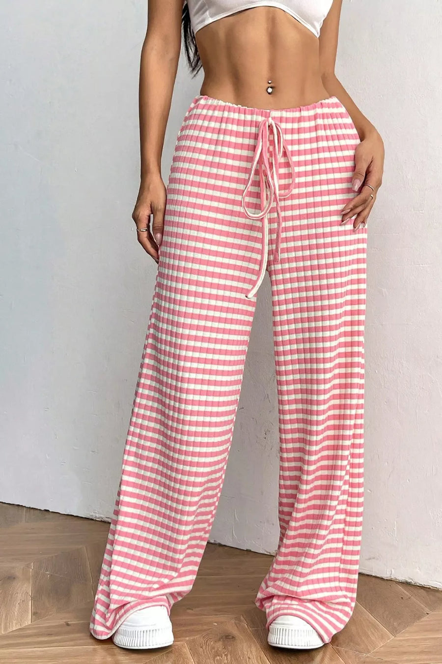 Person wearing pink and white checkered pants on a plain background