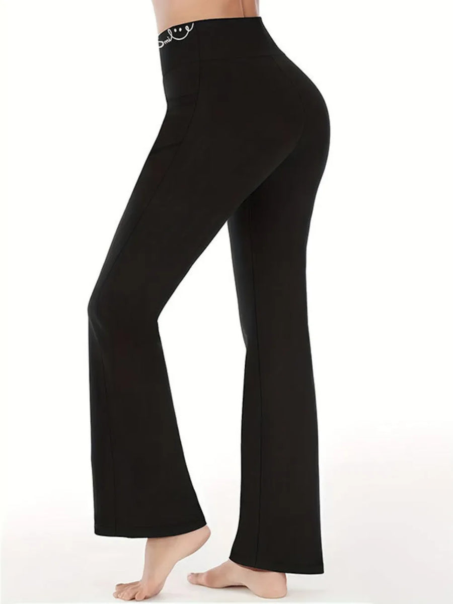 Black bell-bottom pants worn by a person on a white background