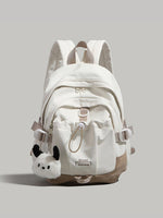 White backpack with plush toy attachment on a light gray background