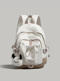 White backpack with plush toy attachment on a light gray background
