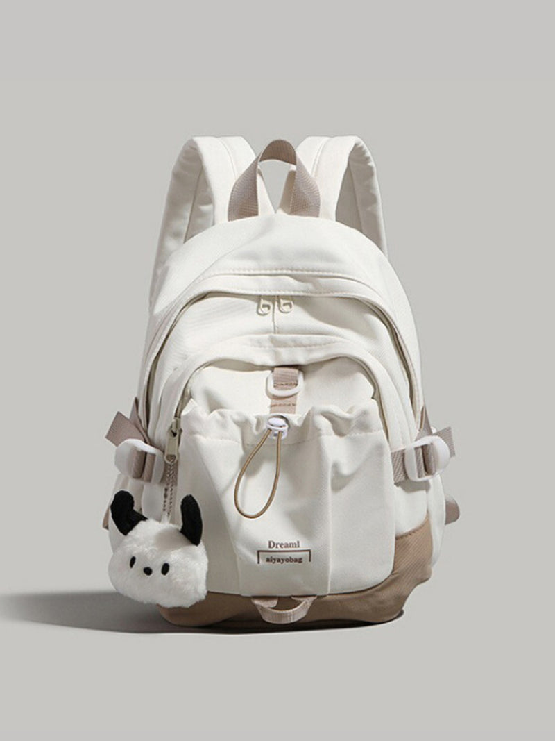 White backpack with plush toy attachment on a light gray background