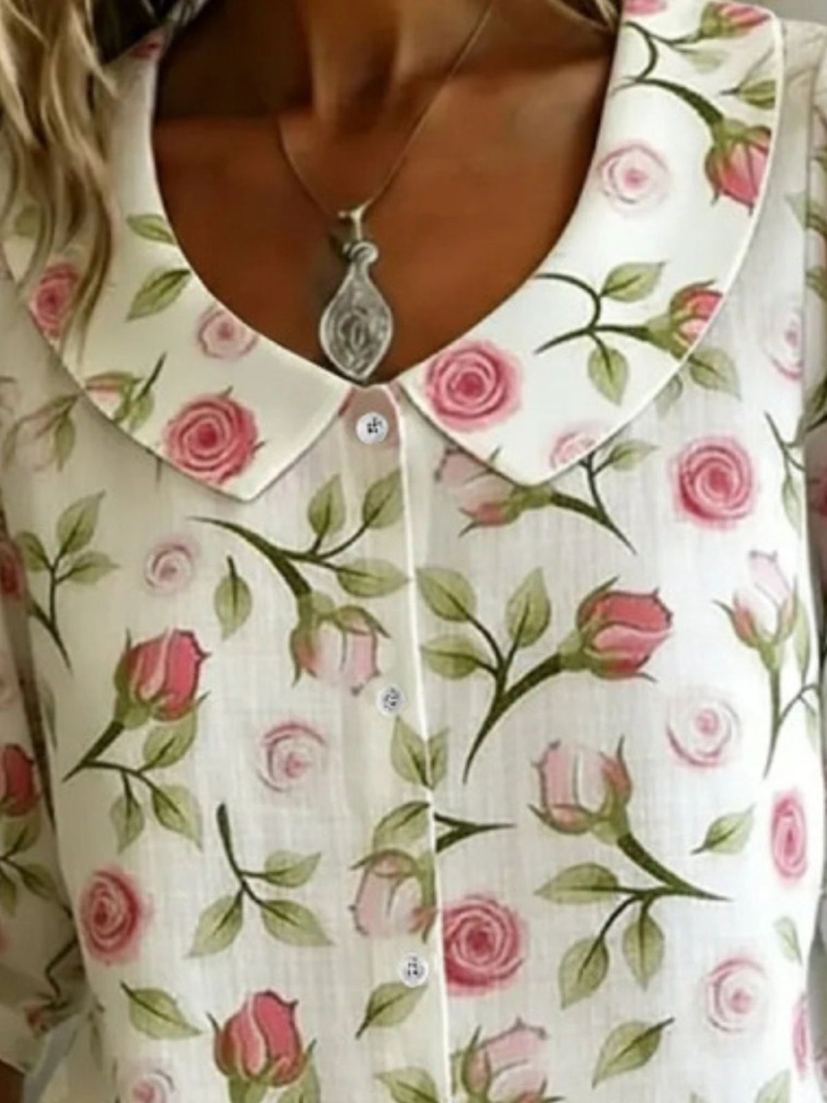 Close-up of a floral-patterned blouse with a necklace.