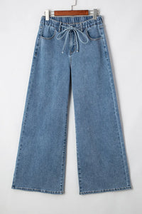 Blue jeans on a hanger against a white background