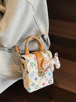Small handbag with colorful logo pattern worn by a person